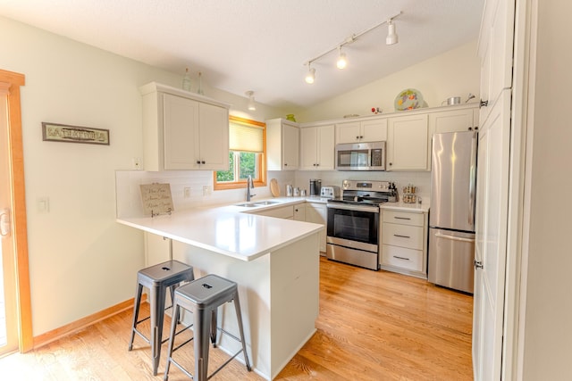 1434 Benson Blvd E, Stillwater, MN 55082 - kitchen with appliances with stainless steel finishes, a sink, tasteful backsplash, a peninsula, and lofted ceiling