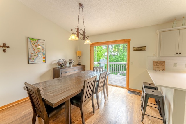 1434 Benson Blvd E, Stillwater, MN 55082 - dining room featuring a textured ceiling, light wood-style flooring, baseboards, and lofted ceiling