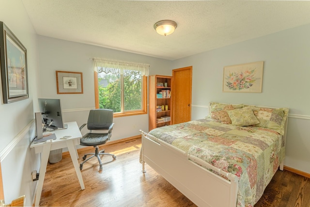 1434 Benson Blvd E, Stillwater, MN 55082 - bedroom featuring an office area, wood finished floors, a textured ceiling, and baseboards
