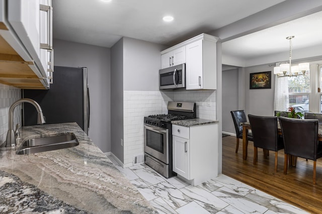 5548 34th Ave S, Minneapolis, MN 55417 - kitchen with appliances with stainless steel finishes, a sink, dark stone counters, a chandelier, and recessed lighting