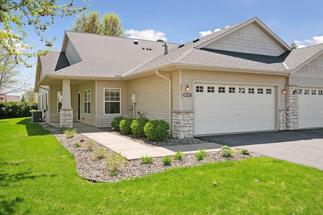 view of front of house with central AC unit, a shingled roof, stone siding, and an attached garage