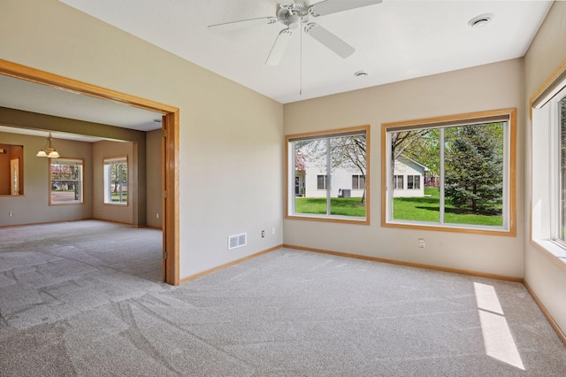 carpeted empty room with baseboards and a ceiling fan