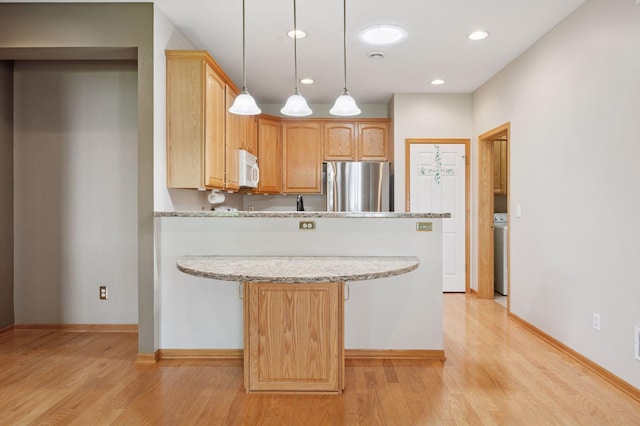 kitchen with freestanding refrigerator, a peninsula, white microwave, light wood-type flooring, and recessed lighting
