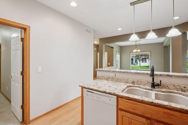 kitchen with dishwasher, a sink, light stone counters, decorative light fixtures, and recessed lighting