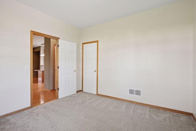 unfurnished bedroom with light carpet and baseboards
