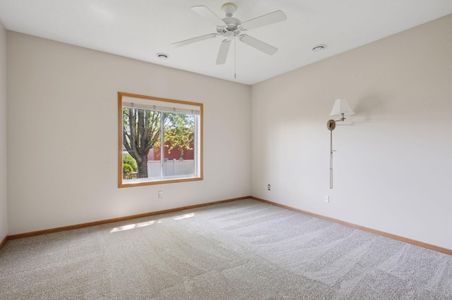 unfurnished room featuring carpet floors, baseboards, and a ceiling fan