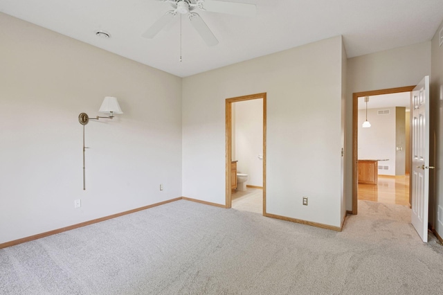 unfurnished bedroom with light carpet, baseboards, ensuite bath, and ceiling fan