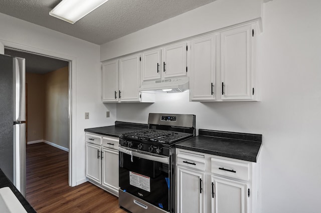 10276 Hanson Blvd NW, Coon Rapids, MN 55433 - kitchen with stainless steel appliances, under cabinet range hood, dark countertops, dark wood-style floors, and white cabinetry