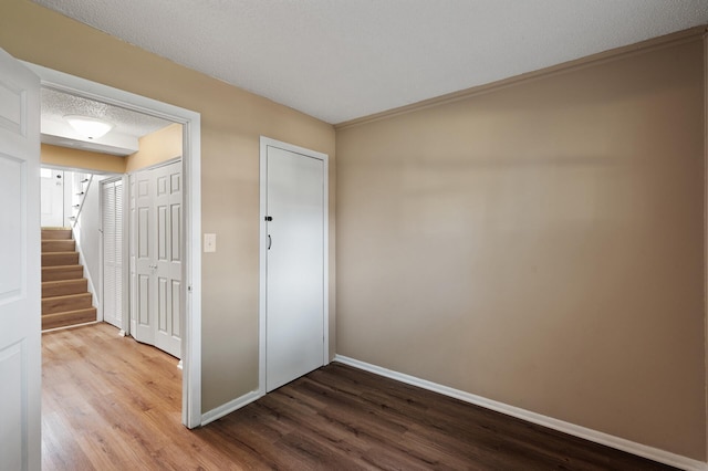 10276 Hanson Blvd NW, Coon Rapids, MN 55433 - unfurnished bedroom featuring wood finished floors, baseboards, and a textured ceiling