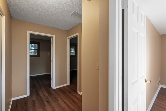 10276 Hanson Blvd NW, Coon Rapids, MN 55433 - corridor featuring dark wood finished floors, baseboards, and a textured ceiling