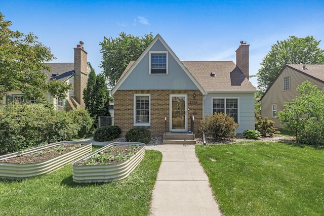3259 Zarthan Ave S, Saint Louis Park, MN 55416 - tudor home featuring a vegetable garden, a front yard, brick siding, and roof with shingles
