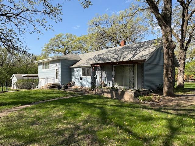 1300 10th St NE, Sauk Rapids Twp, MN 56379 - rear view of property with a yard and a chimney