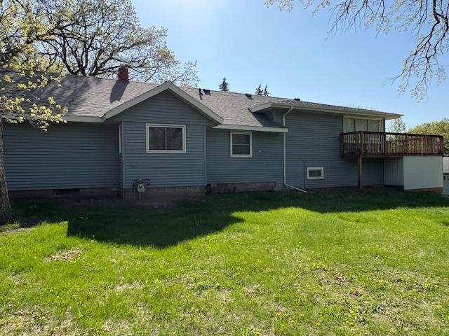 1300 10th St NE, Sauk Rapids Twp, MN 56379 - rear view of house with a lawn, a deck, and a chimney