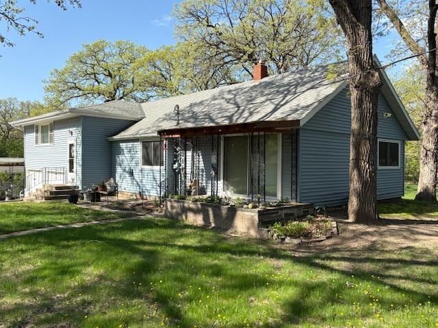 1300 10th St NE, Sauk Rapids Twp, MN 56379 - rear view of house with a lawn, a chimney, and a shingled roof