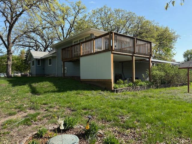 1300 10th St NE, Sauk Rapids Twp, MN 56379 - view of property exterior with a wooden deck and a lawn