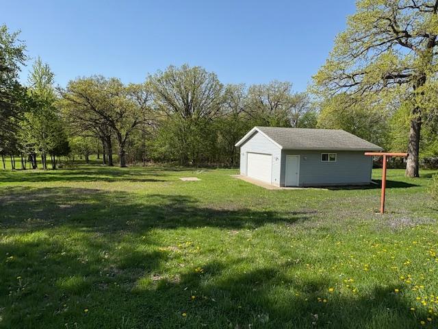 1300 10th St NE, Sauk Rapids Twp, MN 56379 - view of grassy yard featuring a garage and an outdoor structure