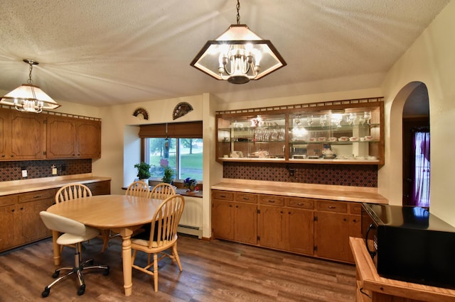 1300 10th St NE, Sauk Rapids Twp, MN 56379 - dining room featuring a chandelier, arched walkways, dark wood-style floors, and a textured ceiling