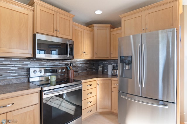 kitchen featuring stainless steel appliances, light brown cabinets, dark countertops, tasteful backsplash, and recessed lighting