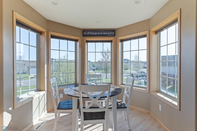 sunroom with baseboards and wood finished floors