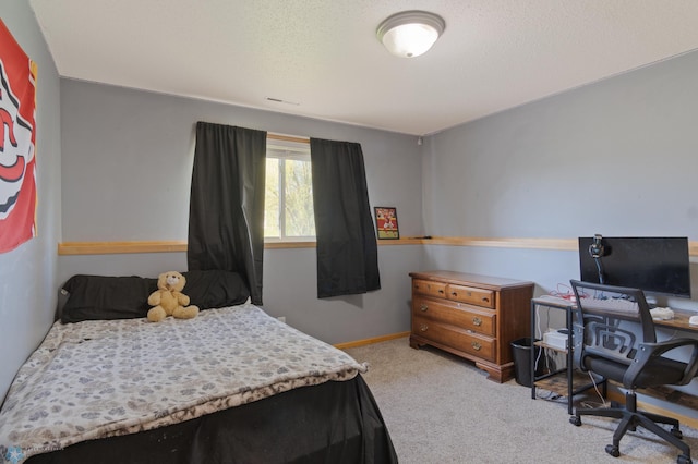 carpeted bedroom featuring a desk and baseboards