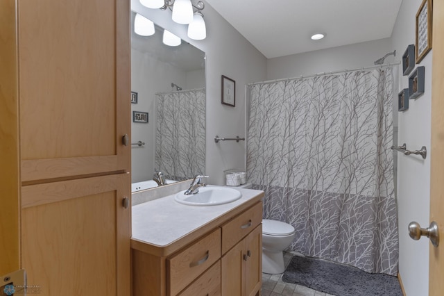 bathroom with toilet, vanity, and curtained shower