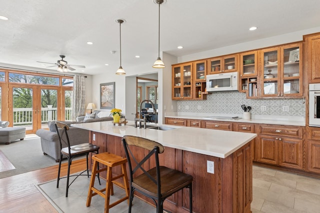 6715 Eldorado Way, Leon Twp, MN 55009 - kitchen with white appliances, a sink, brown cabinetry, a breakfast bar area, and open floor plan