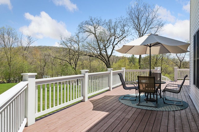 6715 Eldorado Way, Leon Twp, MN 55009 - wooden deck with outdoor dining space and a view of trees