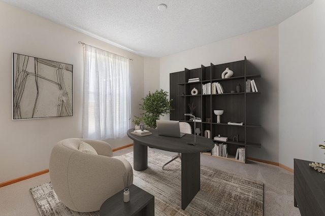 carpeted office space featuring baseboards and a textured ceiling