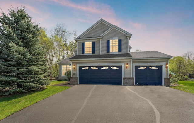 traditional-style home with asphalt driveway, an attached garage, and brick siding