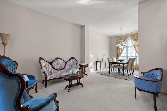 sitting room with a chandelier, carpet, and a textured ceiling