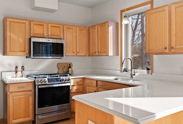 kitchen with stainless steel appliances, a sink, and light countertops