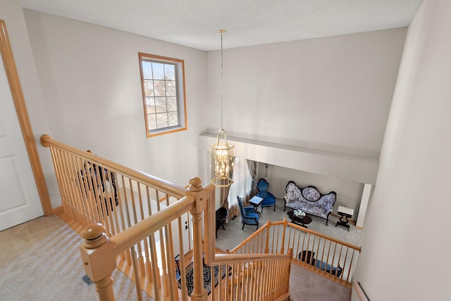 stairs with carpet, a chandelier, and baseboards