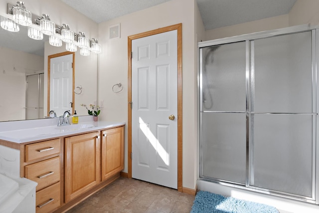 bathroom featuring a shower stall and vanity