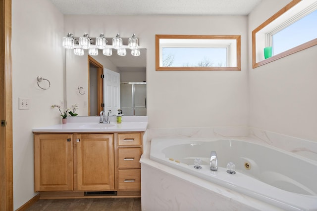 full bathroom with a stall shower, vanity, and a tub with jets
