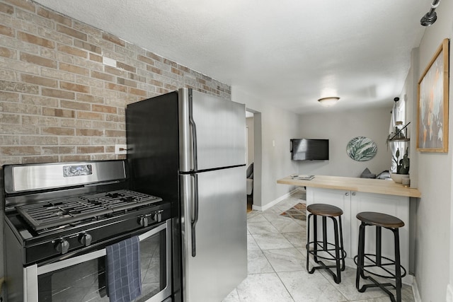 1541 Charles Ave, Saint Paul, MN 55104 - kitchen featuring stainless steel appliances, a kitchen breakfast bar, baseboards, a peninsula, and wood counters
