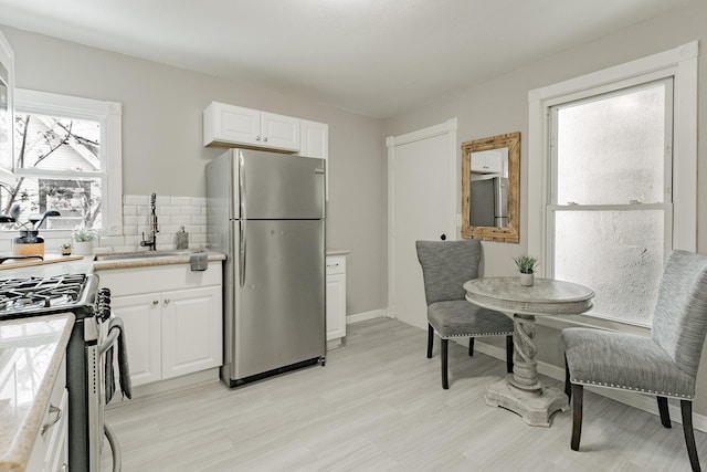 1541 Charles Ave, Saint Paul, MN 55104 - kitchen featuring appliances with stainless steel finishes, white cabinetry, light countertops, and a sink