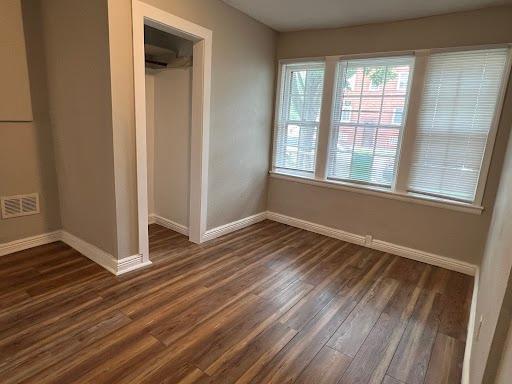 1541 Charles Ave, Saint Paul, MN 55104 - unfurnished bedroom featuring baseboards, dark wood-type flooring, and a closet
