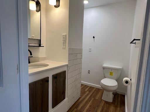 1541 Charles Ave, Saint Paul, MN 55104 - bathroom featuring wood finished floors, vanity, and toilet