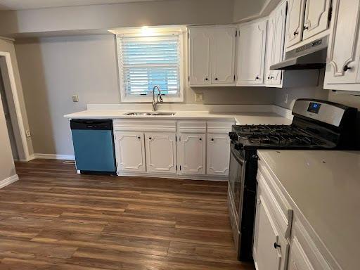 1541 Charles Ave, Saint Paul, MN 55104 - kitchen with under cabinet range hood, dishwasher, stainless steel gas range oven, a sink, and dark wood-style floors