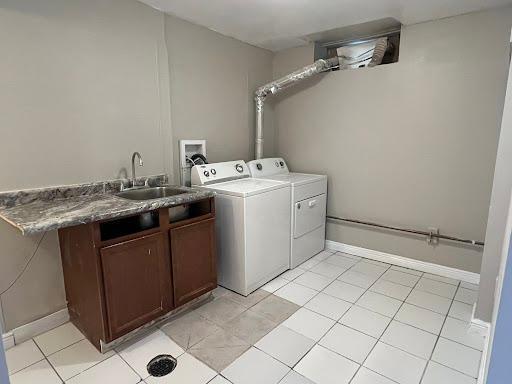 1541 Charles Ave, Saint Paul, MN 55104 - laundry room with cabinet space, independent washer and dryer, baseboards, and light tile patterned floors