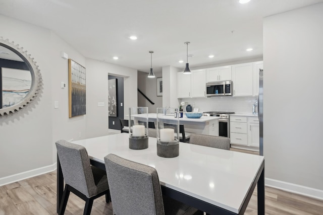 dining space featuring light wood-style flooring, recessed lighting, and baseboards