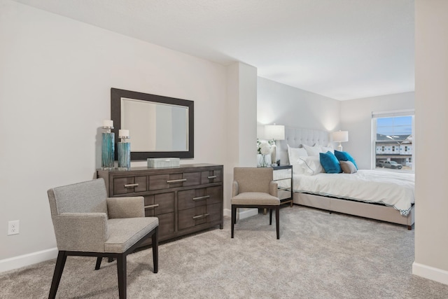 bedroom featuring light colored carpet and baseboards