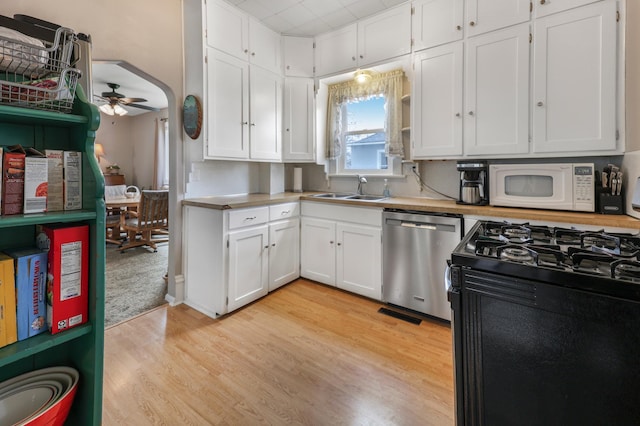 110 7th St SE, Little Falls, MN 56345 - kitchen featuring dishwasher, white microwave, a sink, white cabinetry, and light countertops