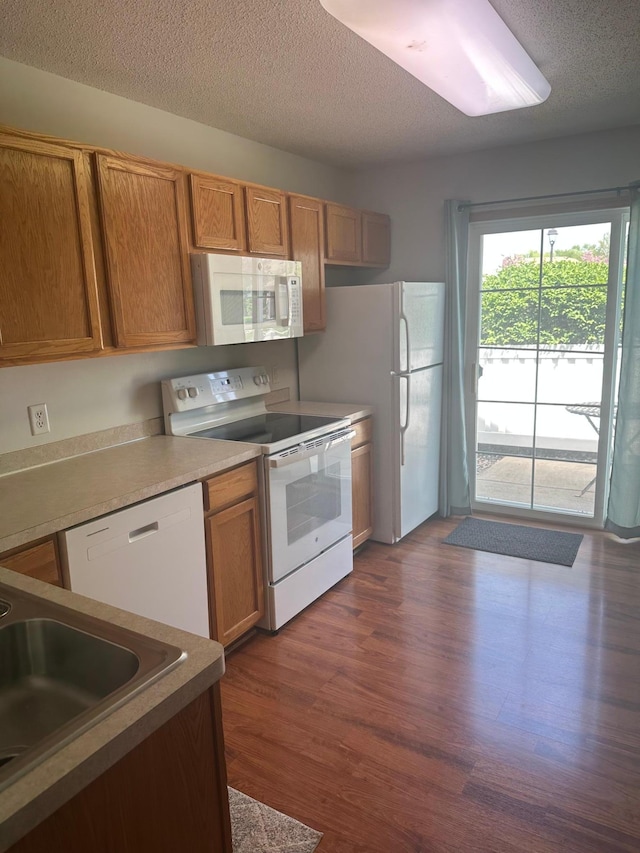 9277 Inland Ln N, Maple Grove, MN 55311 - kitchen featuring white appliances, dark wood-type flooring, a textured ceiling, brown cabinets, and a sink