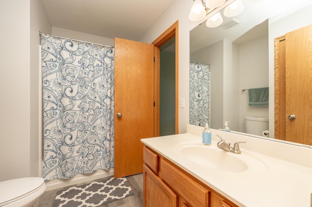 9277 Inland Ln N, Maple Grove, MN 55311 - full bathroom featuring toilet, vanity, and wood finished floors