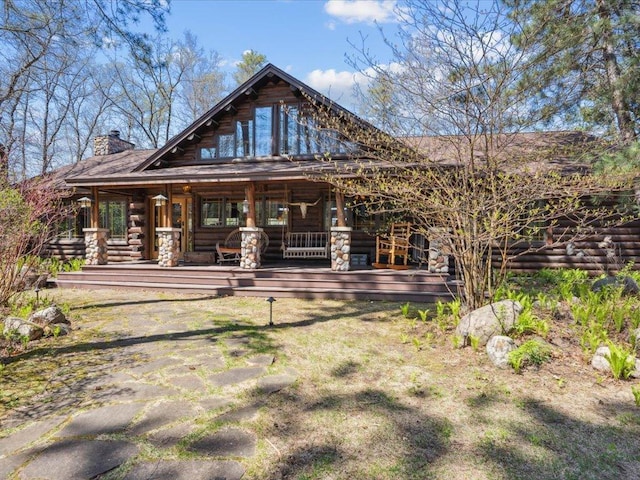 15464 Birch Narrows Rd, Crosslake, MN 56472 - back of house featuring log exterior, a porch, and a chimney