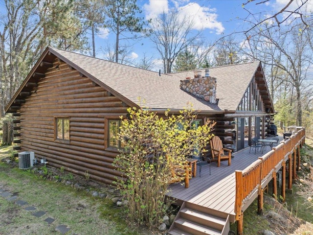 15464 Birch Narrows Rd, Crosslake, MN 56472 - view of property exterior with log siding, a wooden deck, a chimney, a shingled roof, and cooling unit