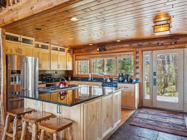 15464 Birch Narrows Rd, Crosslake, MN 56472 - kitchen featuring wooden ceiling, a kitchen island, appliances with stainless steel finishes, a breakfast bar area, and dark stone counters
