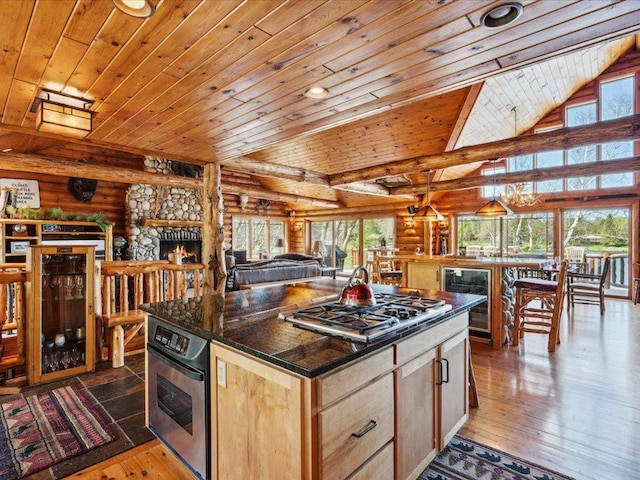 15464 Birch Narrows Rd, Crosslake, MN 56472 - kitchen with beverage cooler, rustic walls, stainless steel appliances, wood ceiling, and light brown cabinetry