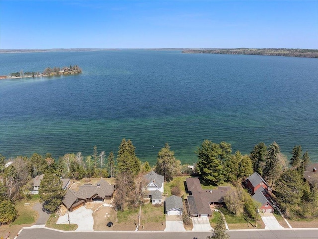aerial view of property and surrounding area with a large body of water and nearby suburban area